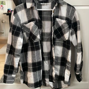 Rutig skjorta/jacka - Säljer denna skjorta i lite tjockare material, så den funkar som en tunnare jacka till våren eller sommaren. Väldigt fint skick utan defekter. Knappar längst ner i ärmarna och två fickor fram. Säljer   för 70kr. Skriv t mig för mer info💕