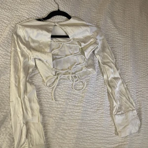 Blus  - Långärmad croppad blus med snörning i ryggen från Zara. 