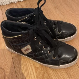 Guess skor svarta - Svarta guess skor med guld detaljer