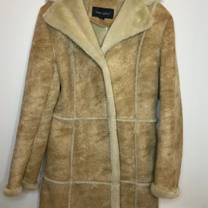 Kappa med fakepäls - Jättefin kappa med detaljer av fuskpäls. I strl 34.