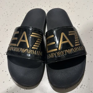 Ea7 tofflor  - Hej lite dom är lite andvända men dom är topp skick en då dom är storlek 45 och är äkta 