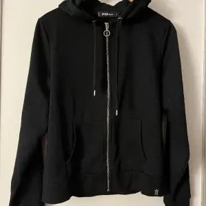 Snygg svart zip up hoodie. Använd men är i otroligt bra skick! Står storlek L i den men är som en S.  Ps! Jag säljer en likadan i grå, båda för 100kr! 