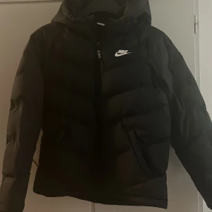 Nike pufferjacka  - Säljer denna Nike puffjacka då den inte kommer till användning. Jackan har inga defekter och är i storlek 147-158 cm men passar mig som har storlek S. Köpt för 1000 men säljer för 500! (kan diskuteras)  OBS välj gärna instabox som fraktalternativ! 