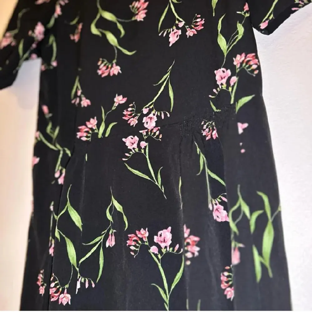 Denna klänning från H&M är i bra skick och perfekt till alla tillfällen! Den är inte tight i midjan och rätt så lång. Fint mönster med rosa blom buketter och gröna löv. Storlek EU 38/US 8. Klänningar.