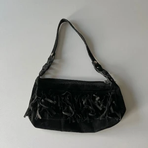 Handväska - Svart mocka handväska med fransar. Längd: ca 26 cm. Djup: 5,5 cm. Höjd: 11,5 cm 🖤