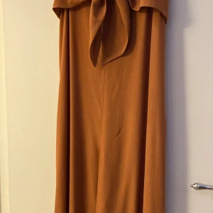 Byxdress från & other stories - Byxdress från & other stories. Aldrig använd. Strl 38. Rostfärgad. Köparen står för frakt