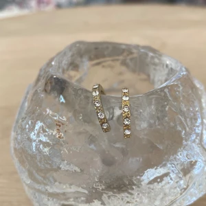 Guldiga fejk diamant örhängen - Det är inte äkta Edblad men det ser ut som om.  Orgenal priset är ca 110kr. Har en liten röd prick bakom öronhänget  