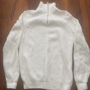 Vit Stickad Zip Tröja - En vit stickad zip tröja i bra skick, använt den 1 eller 2 gånger. Säljer eftersom den var lite för stor på mig.   Tveka inte på höra av dig vid intresse 🌟