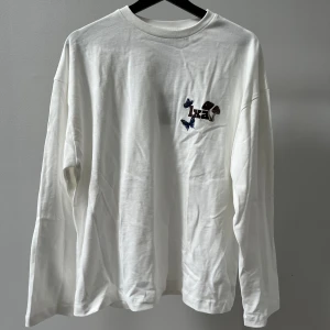 Vit långärmad LXA - Vit långärmad med broderi på från Linn Ahlborgs märke LXA. Stor i storleken/oversized modell. Aldrig använd och med prislappen kvar. Nypris 590kr. ”Forest long sleeve tee”.