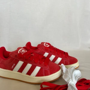 Adidas Campus 00’s ”Better Scarlet❤️” - Säljer ett par röda Adidas Campus 00’s ”Better Scarlet” i storlek 36, HELT NYA. Röda samt vita skosnören medkommer. Kommer med orginalbox. Kan mötas i Stockholm samt fraktas