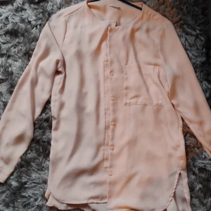 Rosa blus genomskinlig stl m - En rosa genomskinlig blus med knappar storlek m