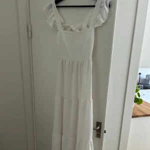 Vit långklänning  - Vit långklänning. Säljs då den inte kommer till användning tyvärr! Går nästan ner till marken på mig som är 1,67 cm lång. 