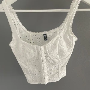 Fin Korsett topp - Jättefin korsettopp som knappt är använd pga för liten vid bysten. Kommer från H&M divided och är i storlek 34. Skulle säga passa A kupa eller eventuellt liten B kupa. Fint mönster och passar bra till sommaren/fest. 