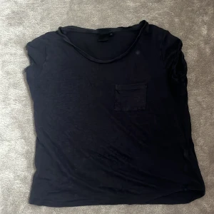 Linne T-shirt  - Mörkblå tshirt med en liten ficka på bröstet.