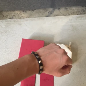 Valentino armband - Tja! Säljer nu mitt asfeta valentino armband då det bara ligger i rummet, Box dustbag och extra nitar medföljer, väldigt bra skick, sömmen har gått upp lite men spelar ingen roll när armbandet är på.