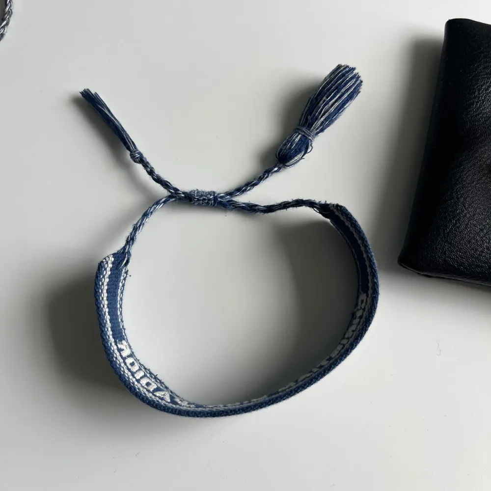 Säljer ett dior armband, nåra snören har lossnat på ena sidan, det syns på bild 3, annars är det i fint skick, storlek går att ändra, priset kan diskuteras vid snabb affär, hör av er vid funderingar!. Accessoarer.