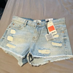 Ljusa jeansshorts från MNG - Ljusa jeansshorts från MNG med slitna detaljer och fransig nederkant. Shortsen har fem fickor och en knappgylf. Dem är helt oanvända och bara provade på🩷