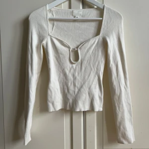 Superfin topp från HM stl: xs  - Superfin krämvit tröja i ett stickat matrial från HM, fin ringning med en pärla, använd 2 gånger, storlek xs.