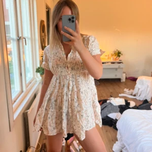 Blommig klänning  - Blommig klänning med knappar. För kort på mig som är 170. Lite klippt vid ärmarna för mer plats. Hör av er vid frågor💗