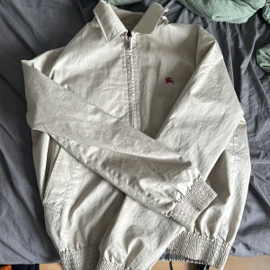 Burberry jacka - Säljer denna vintage burberry jacka i fint skick utan skador, den har dock en fläck på ryggen som inte går bort (sista bilden)