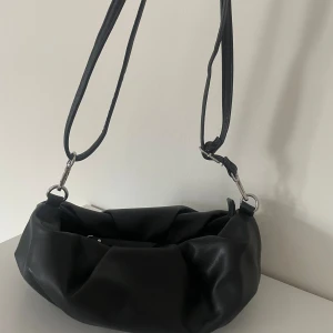 Axelremsväska  - svart axelremsväska vet ej vart ifrån, följer med en kedja men går att ta av🤗