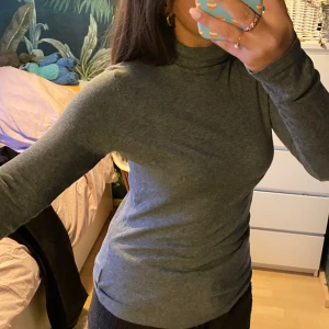 Grå turtleneck - En långärmad turtleneck tröja i tunnt ribbat material. Lång i magen och långa ärmar.  Vet inte riktigt vad storleken är men passar m eller liten L