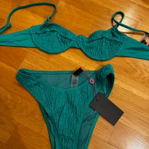 Bikini - Helt ny bikini med tagg kvar, hög benskärning i ett skimrande material 👙
