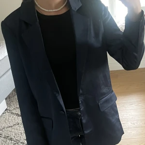 Oanvänd satin blazer  - Blazer/ kavaj i mörkblå satin material, lite over-sized i modellen. Aldrig använd, den är inte uppsprättad i bak eller vid armarna. Strl xs men passar även s Märket är Second Female 