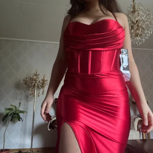 Balklänning  - Säljer denna oanvända balklänning, köptes för 3600kr. Korsett topp, slits till låret och backless med trådar. Passar S-L då du kan justera korsetten med trådarna bakom. Prislappen är kvar 