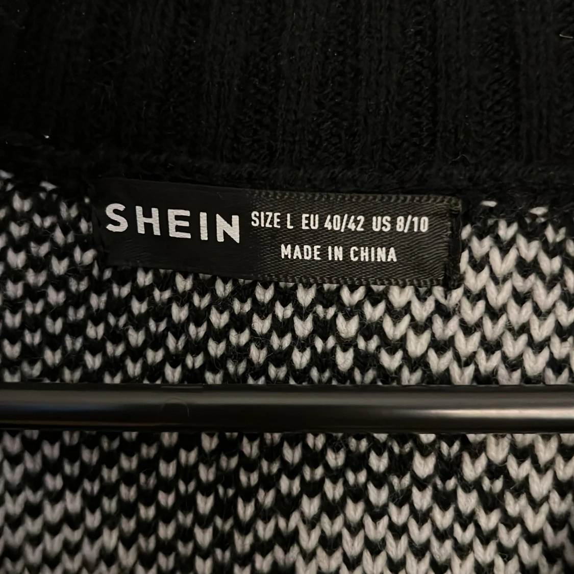 En stickad tröja som är randig svart och vit  - 93