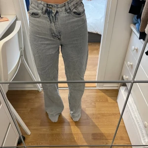 Blå jeans - Högmidjade blå jeans. De har lite slitningar längst ner på byxbenen, men är annars i bra skick!