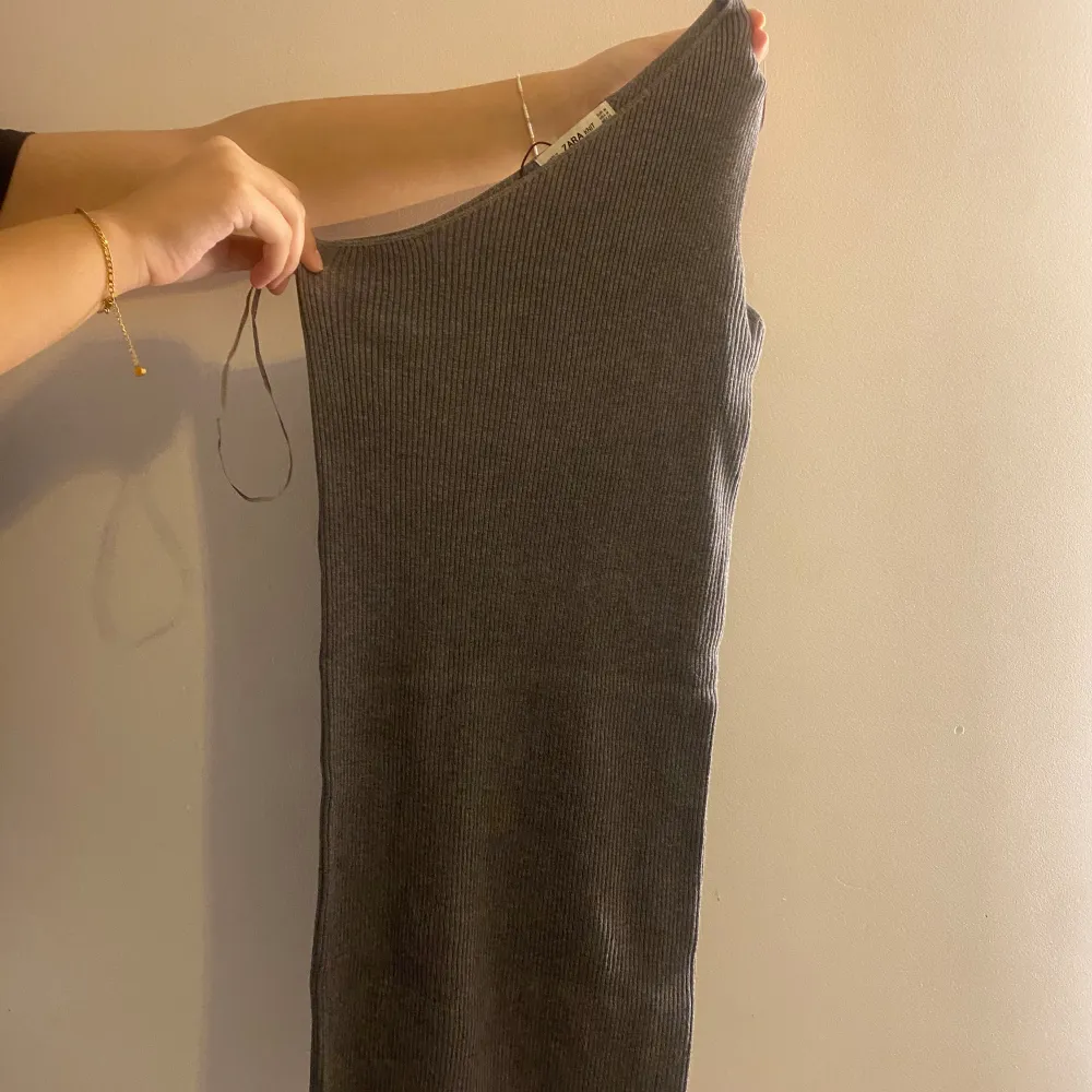 Mörkgråa one oneshoulder klänning från Zara, den är i storlek M men är väldigt liten i storleken skulle säga att den passar mer en Xs/S. . Mekot.