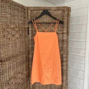 Super snygg kort orange klänning i strl 38, oanvänd 
