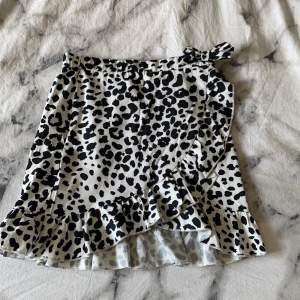 En vit volang kjol med svart leopard mönster. Säljer pågrund utav att jag inte använder. Kjolen har dragkedja så det går att justera lite på storleken. Inga defekter eller märken