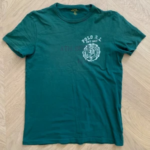 Ralph Lauren t-shirt - Polo Ralph Lauren T-Shirt med snygga detaljer. Storlek S, sitter perfekt på mig som är 177 cm lång. Normal i storlek, tidchan är i fint skick. 