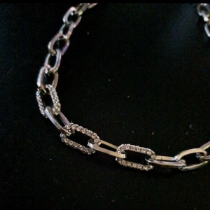 Halsband  - Ett silvrigt halsbandmed glitter detaljer fram, kedjigt, sitter fint runt hals