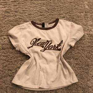 Beige top with New York text
