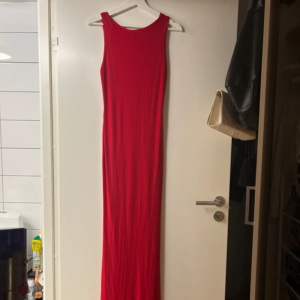 Röd lång klänning (ca 170 lång) med djup öppen rygg. Använd endast en gång. För referens är jag 163 plus klackar) på bilden. Storlek 38 men passar mig som är 34/36/38. Gjord på 95% polyester.. Klänningar.