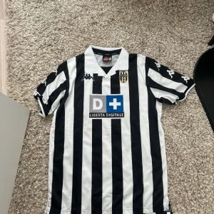 Juventus retro matchtröja kappa - Retro tröja inköpt i Asien, sitter som en L i Europastorlek. Som ni ser blev trycket på bilden lite misslyckat. Hämtas i Nacka Strand, frakt ingår inte i priset.