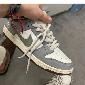 Nike SB Dunk Low 'Yuto Horigome' - Säljer ett par Nike SB Dunk Low 'Yuto Horigome' sneakers i storlek herr 44. Skorna är i grått, vitt och brunt med en snygg design och snörning. Perfekta för både vardag och skateboarding. De är i befintligt skick och kommer med originalförpackning.