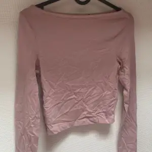 En rosa långärmad topp från ASOS DESIGN. Toppen har en enkel design med en tight passform.