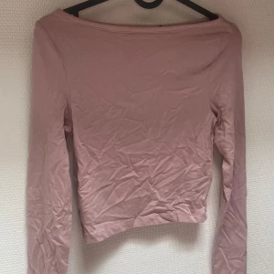 Rosa långärmad topp från ASOS DESIGN - En rosa långärmad topp från ASOS DESIGN. Toppen har en enkel design med en tight passform.