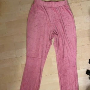 Rosa mjukisbyxor - Säljer ett par supermysiga rosa mjukisbyxor. De är gjorda av ett mjukt och skönt material som känns som sammet. Perfekta för en chill dag hemma eller för att mysa i soffan. Byxorna har en hög midja och en loose passform som gör dem extra bekväma. De är i nyskick och har knappt använts.