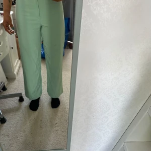 Mintgröna byxor från Shein - Säljer ett par snygga mintgröna byxor från Shein i storlek XS. Byxorna är högmidjade och har en rak passform. De är gjorda av ett lätt och bekvämt material, perfekt för vår och sommar. Byxorna har en dragkedja och knapp framtill.