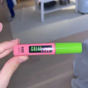 Säljer en Great Lash Mascara från Maybelline. Den har en rosa tub med en grön kork och svart text. Mascaraborsten är täckt med svart mascara som ger volym och definition till fransarna. Perfekt för en dramatisk look! 💖