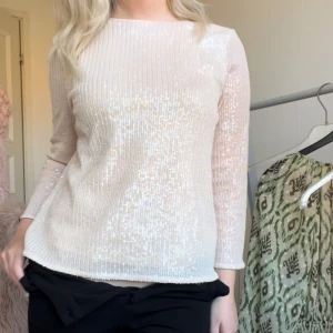 Vit glittrig topp - Säljer en snygg ljus rosa glittrig topp som passar perfekt för festliga tillfällen. Toppen har långa ärmar och en tight passform som framhäver figuren. Materialet är mjukt och bekvämt, vilket gör den skön att bära hela kvällen. Passar även perfekt för att ha i skolan då den kan piffa upp en mer vardaglig outfit🩷🩷