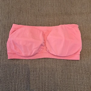 Rosa tubtopp - Säljer en söt rosa tubtopp. Den är ärmlös och har en tight passform. Perfekt för sommaren eller festliga tillfällen. Toppen är gjord av ett mjukt och stretchigt material som gör den bekväm att bära.