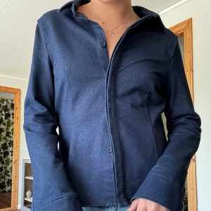 Mörkblå jeansskjorta  - Säljer en figursydd och supersnygg jeansskjorta från Zara. Storlek L men liten i storleken, så passar S/M beroende på hur man vill att den sitter! Använd fåtal gånger. 