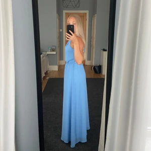 Blå klänning  - En blå fin långklänning med spets i ryggen. Perfekt för bal, bröllop och finare tillställningar. Lagom längd för mig som är ca 165cm lång. Använd endast en gång. 