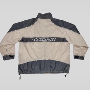 Vintage Southpole Jacka  -  Skick 6,5/10 ser mycket bra ut, det finns inga hål, fläckar eller andra skador på materialet. Defekterna inkluderar ett trasigt blixtlåshandtag, men det är lätt att fixa, själva blixtlåset fungerar fortfarande.